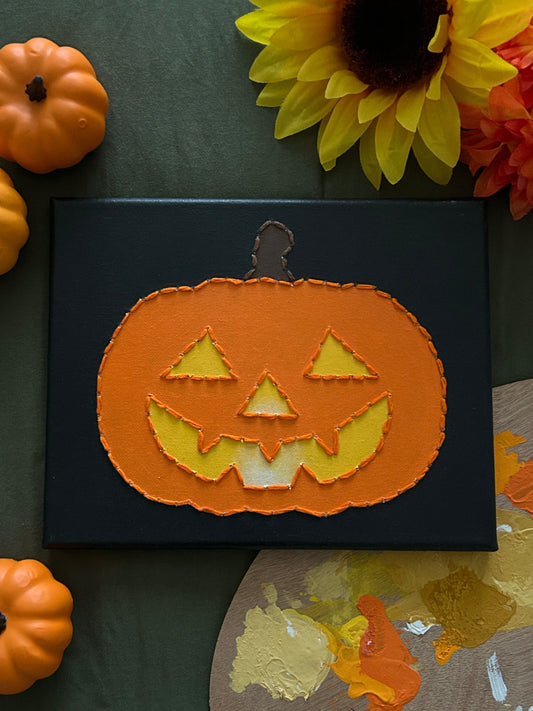 Amber Peeks Art: Pumpkin face decoration on a black background with pumpkins and sunflowers around